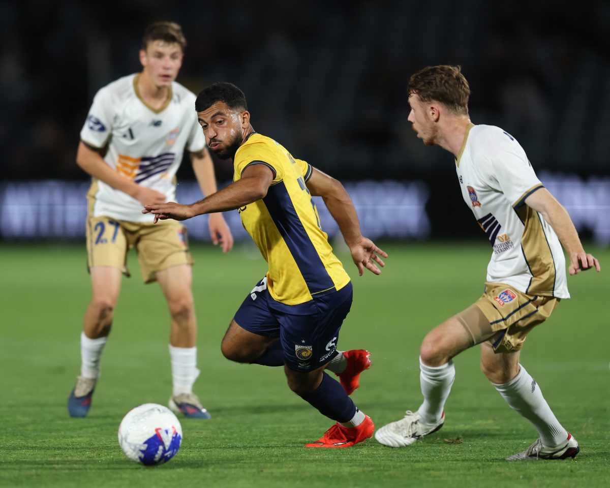 Ali Auglah of the Mariners competes for the ball with Daniel Wilmering of the Jets at Polytec Stadium.